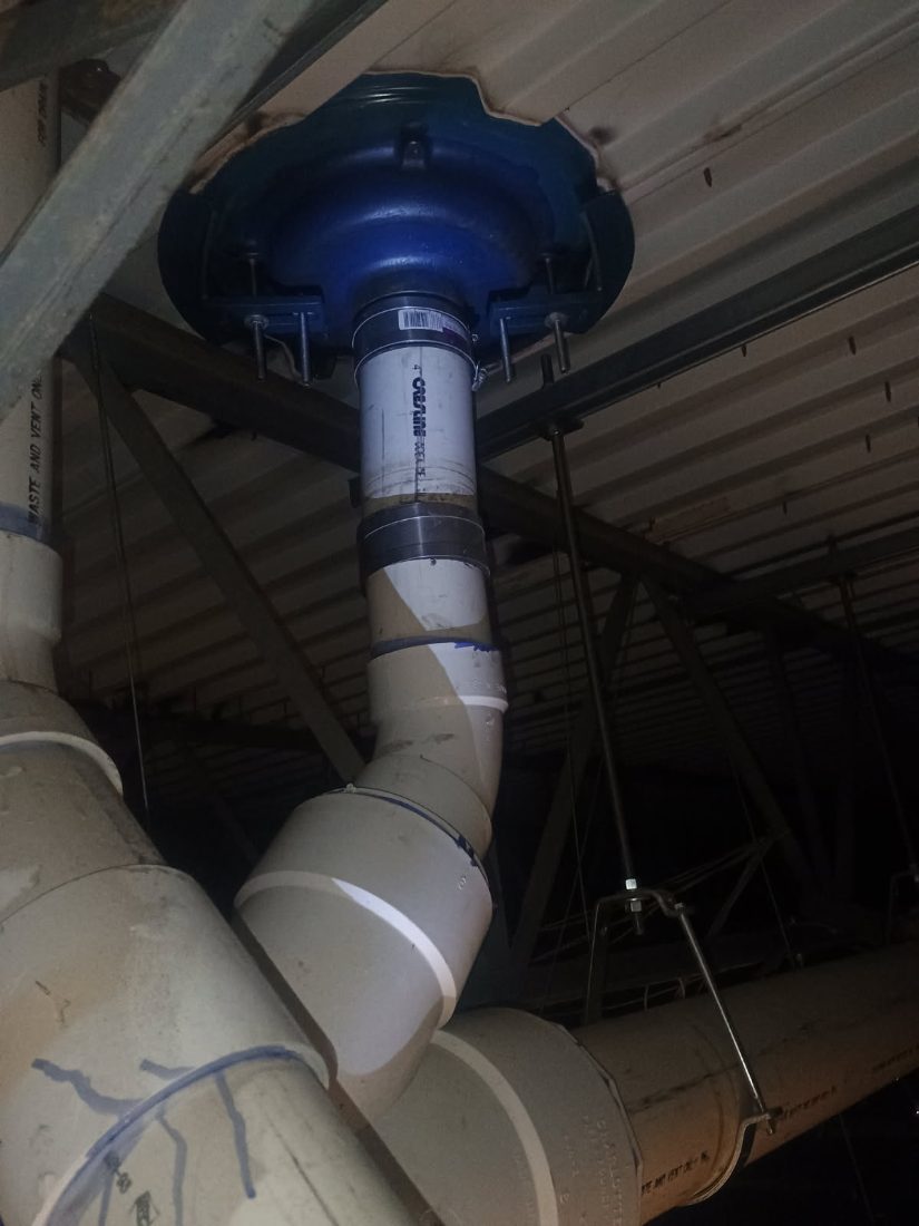 Blue ductless exhaust vent with white PVC pipe mounted to wooden ceiling