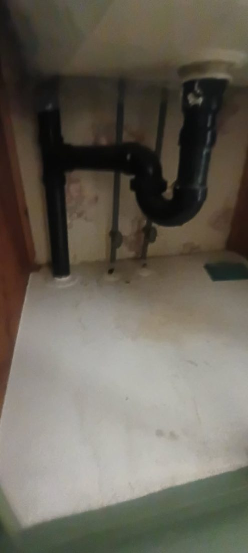 Black PVC pipes and fittings under sink plumbing installation
