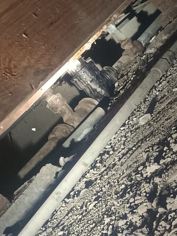Underground pipes and conduits with mineral deposits and gravel surrounding them